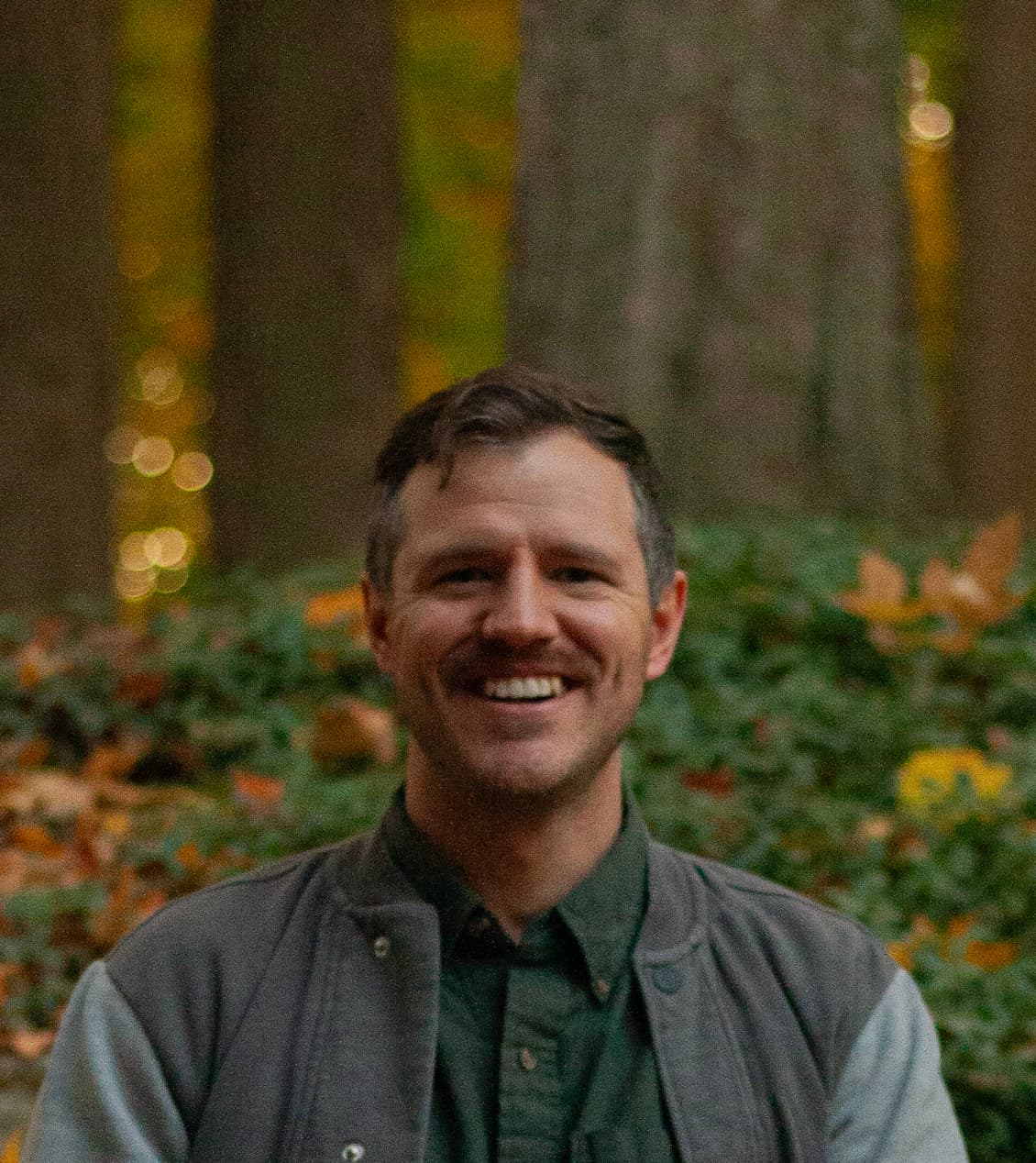 Andrew VanDyke smiling in an autumn forest